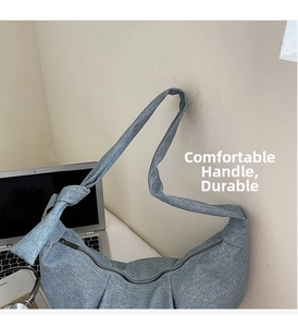 Detail shot of the light blue denim texture tote with a large shoulder strap knot