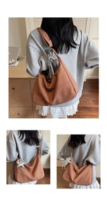 Detail der braunen Web-Hobo-Tasche mit Sternanhänger und breitem Riemen am Modell