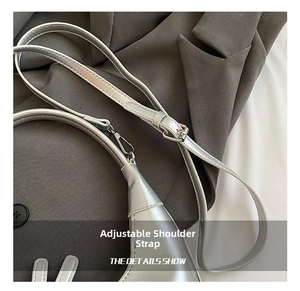 Close-up of the adjustable shoulder strap and silver metallic texture of this crescent bag
