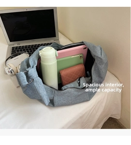 Spacious interior of a grey oversized shoulder bag with various daily items inside