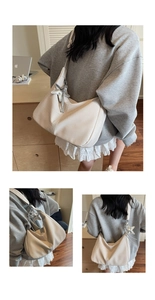 Detail der cremefarbenen Hobo-Bag mit silbernem Sternanhänger und breitem Textilriemen