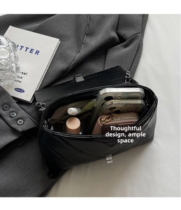 Top view of black quilted crossbody bag interior with silver chain strap and storage space