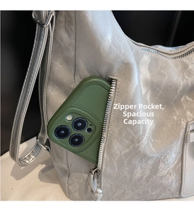 Detail showing the practical side zipper pocket for storing a smartphone in a silver tote