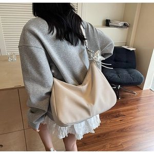 Macro view of cream white hobo bag with lychee grain texture and star charm