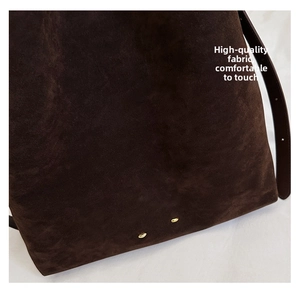 Macro detail of dark brown matte suede fabric with round golden metal hardware studs