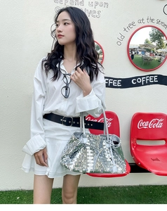 Detail of silver sequin tote bag with drawstring, styled for a street fashion look