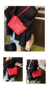 Detalle del bolso tote rojo calado con corte láser y correas de hombro minimalistas