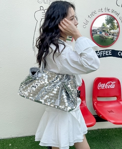 Foto all'aperto di una borsa tote con paillettes argento che mostra la superficie lucida