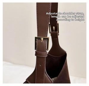 Detail of adjustable shoulder strap with gold square metal buckle on vintage brown tote bag