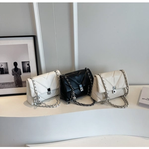 Three quilted leather chain bags in white, black and beige on a modern pedestal