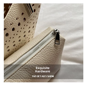 Primer plano de la cremallera de metal plateado y el cuero granulado del bolso tote