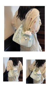 Close-up of mint green tote bag with cloud charm on vintage wooden stairs