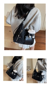 Detail of black nylon tote bag with leather pocket, silver zipper and cloud pendant
