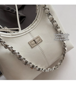 Detail van gebroken witte PU-schoudertas met geplooide textuur en zilveren metalen sluiting