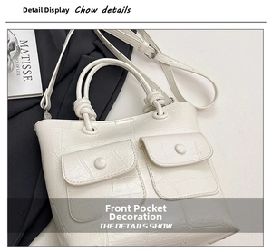 Detail of white crocodile texture handbag with unique knot handle and front pockets