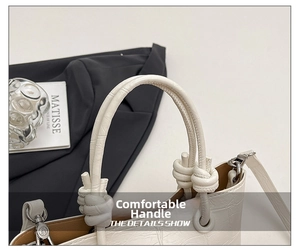 Detailed shot of white faux leather handbag featuring crocodile pattern and knotted handle