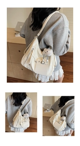 Detail of cream tote bag with wrinkled leather texture and cute cloud charm accessory