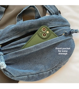Close-up of denim tote bag front zipper pocket showing convenient storage for a phone