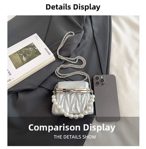 Detail view of silver pleated mini bag with pearl handle and metal chain strap