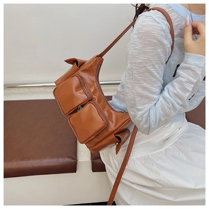 Detail of brown vintage PU leather shoulder bag with functional square zipper pockets