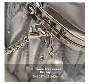 Detail of silver quilted leather bag with metallic hardware and pearl charm decoration
