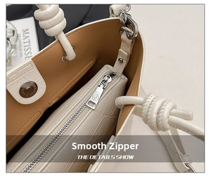 Close-up of white leather handbag interior with crocodile texture pouch and silver zipper