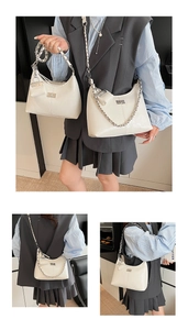Detailweergave van crèmehitte PU-hobo-tas met zilveren ketting en kleine portemonnee