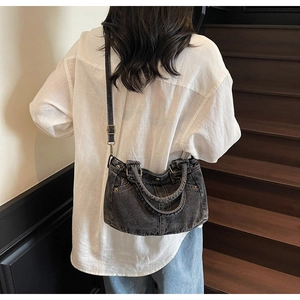 Donna che porta una borsa tote in denim lavato retrò con tracolla su scale d'epoca