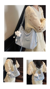 Detail of light blue tote bag with cloud charm and multi-way shoulder straps on model