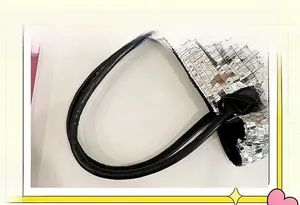 Dettaglio della borsa tote con paillettes argentate e manico nero con riflessi metallici