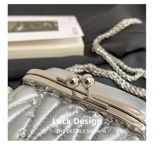 Detail of silver quilted clutch with rhinestone embellishments and round bead clasp