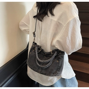 Dettaglio della borsa tote in denim lavato grigio scuro con rivetti e tracolla