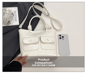 Detail of white crocodile texture handbag showing front flap pockets and knot handle