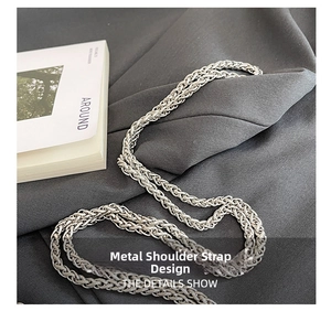 Detail of silver woven metal shoulder strap with intricate chain braided texture