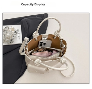 Internal capacity of white crocodile pattern bucket bag showing phone and wallet