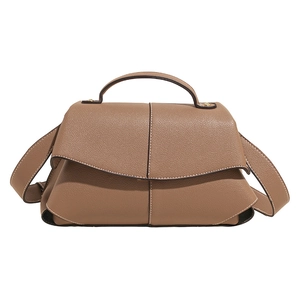 Sac à main en cuir marron texturé avec plis distinctifs et coutures blanches élégantes