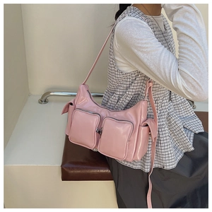 Detail of light pink Y2K shoulder bag with glossy finish and functional multi-pockets