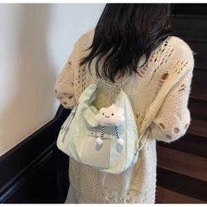 Detail of mint green casual commuter bag with a cute white cloud plush charm decoration