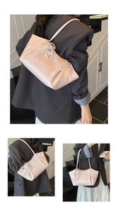 Détail du sac à main rose clair avec nœud en dentelle, chaîne perle et pendentif