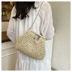 Detail of straw woven bag featuring a vintage metal clasp and elegant gold chain strap
