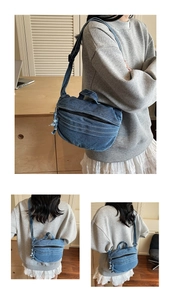 Détails du sac croissant en jean bleu avec texture délavée et large bandoulière réglable