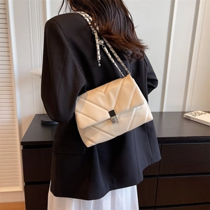 Chic off-white quilted crossbody bag with silver chain strap and stylish V-pattern stitch