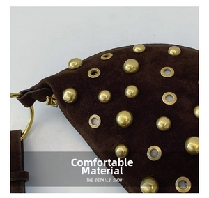 Close-up of brown suede fabric with golden metal studs and eyelets on shoulder bag