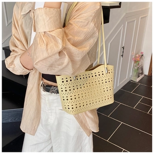 Detalle del bolso tote calado amarillo pálido con patrones geométricos cortados por láser