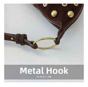 Detail of golden metal hook and rivets on dark brown suede motorcycle shoulder bag