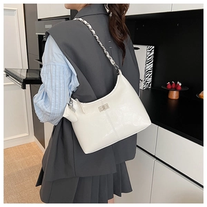 Gros plan d'un sac bandoulière blanc en cuir verni avec chaîne et petit porte-monnaie
