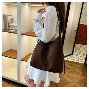 Detail shot of vintage dark brown suede tote bag featuring metallic rivet accents