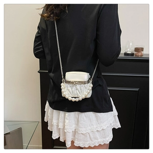 Detailed back view of a white quilted mini bag with pearl handle and rhinestone accents