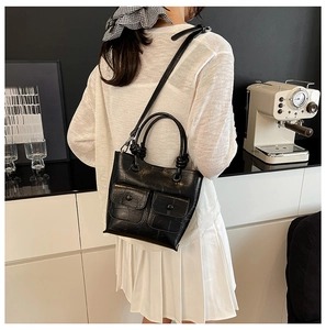 Model wearing a black crocodile pattern crossbody bag with double front flap pockets