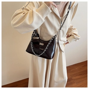 Détail du sac d'épaule en PU brillant noir avec chaîne argentée et mini pochette assortie